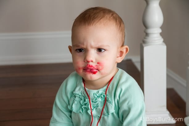 toddler with first time self-applied lipstick