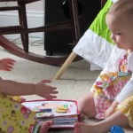 twin girls share quiet book during General Conference