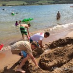 cousins dig a sand castle at the beach