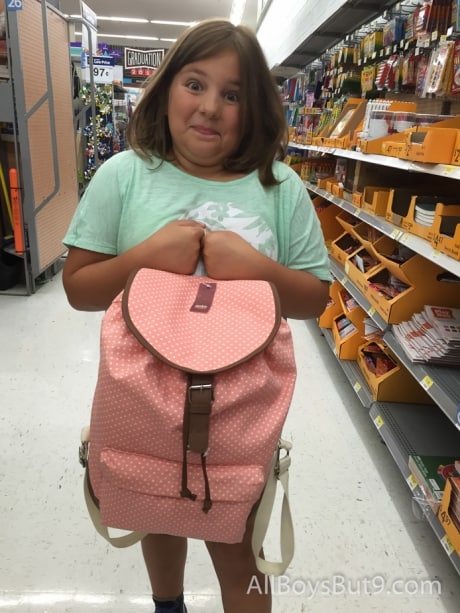 Gracie holding a backpack to fill for school!