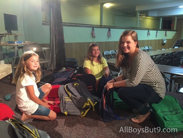 Kate, Esther, and Clara filling backpacks for school children who need them!